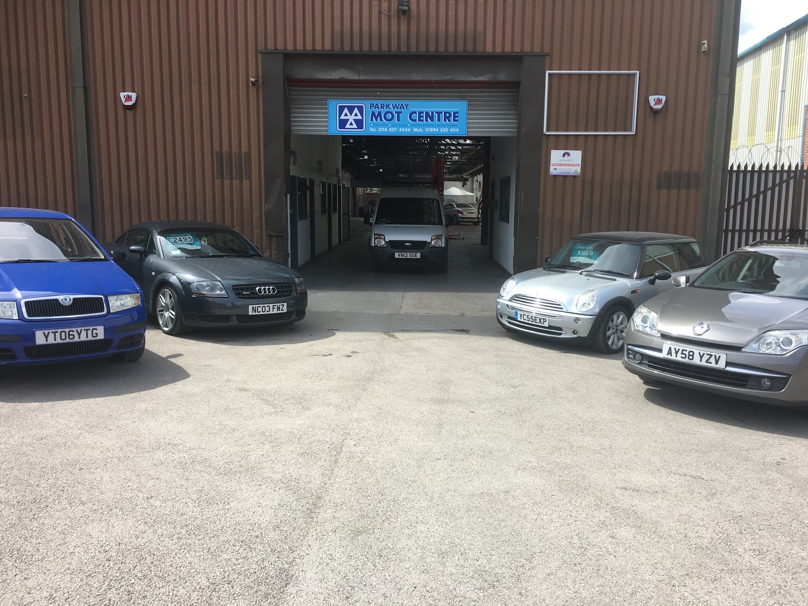 Parkway MOT Centre on Bacon Lane, Sheffield — the open workshop bay with cars on the forecourt